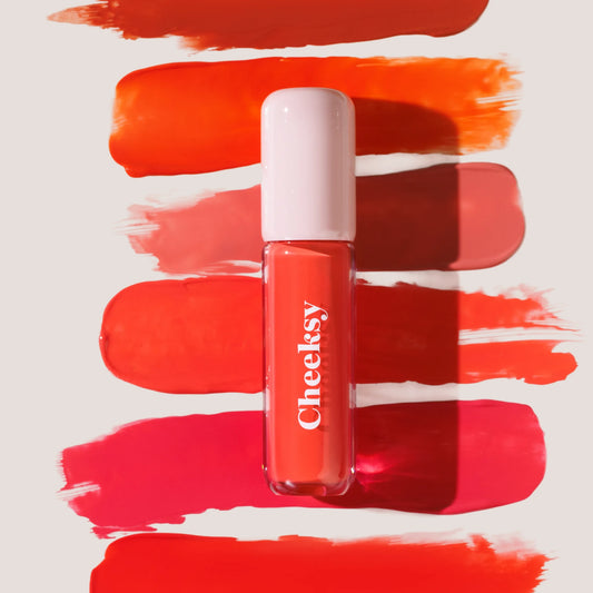 Cheeksy Liquid Blush by By Yglam Beauty, centered against a background of swatches.